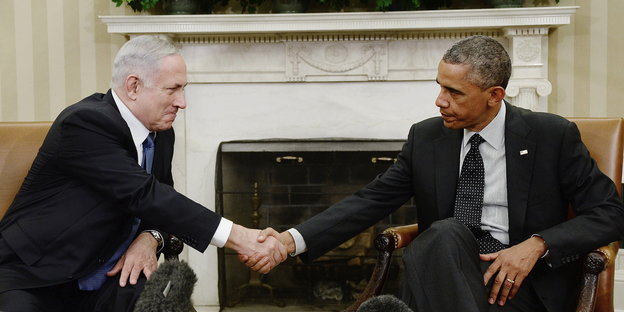Netanjahu (li) und Obama (re) sitzen nebeneinander und schütteln sich die Hände