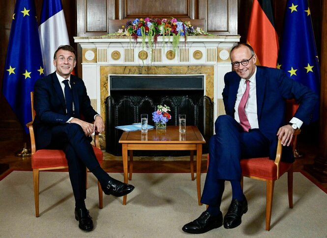 Macron und Merz auf Stühlen