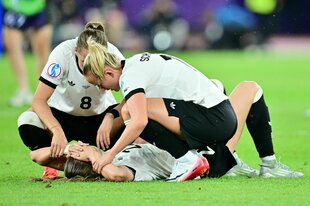 Lea Schüller (r) und Sydney Lohmann (8) trösten die auf dem Rasen liegende Jule Brand