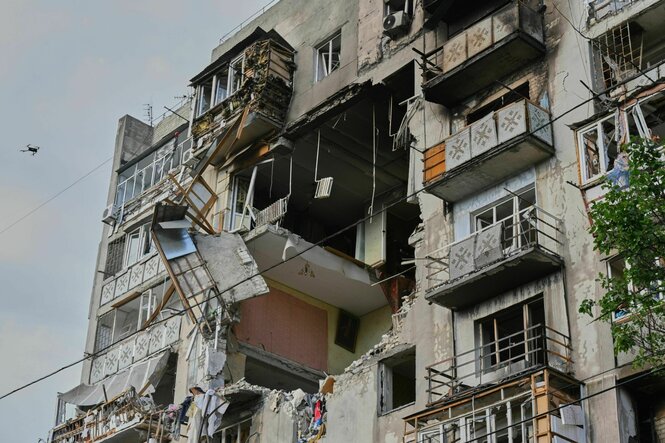 Ein von Bomben getroffenes Mehrfamilienhaus in Odessa, in der Wand klafft ein rießiges Loch, die Holzverkleidung der Balkone hängt in der Luft
