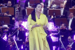 Frau im gelben Kleid vor Orchester