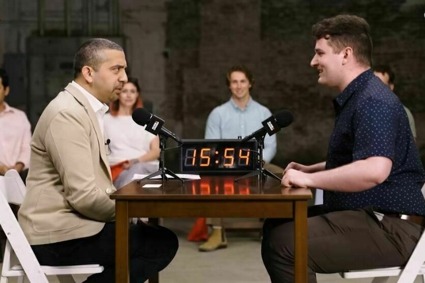 Zwei Personen sitzen sich in einer Fernsehshow gegenüber und debatieren