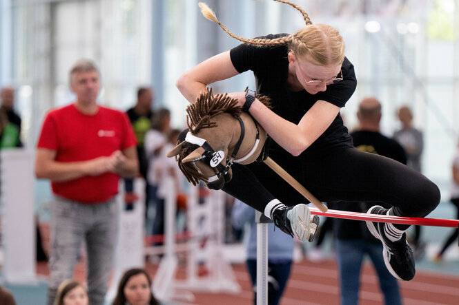 Eine Hobby Horserin überspringt ein Hinderniss