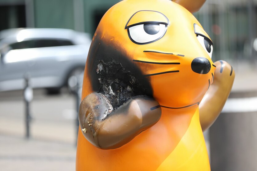 Die Plastikfigur der Maus mit Brandstelle