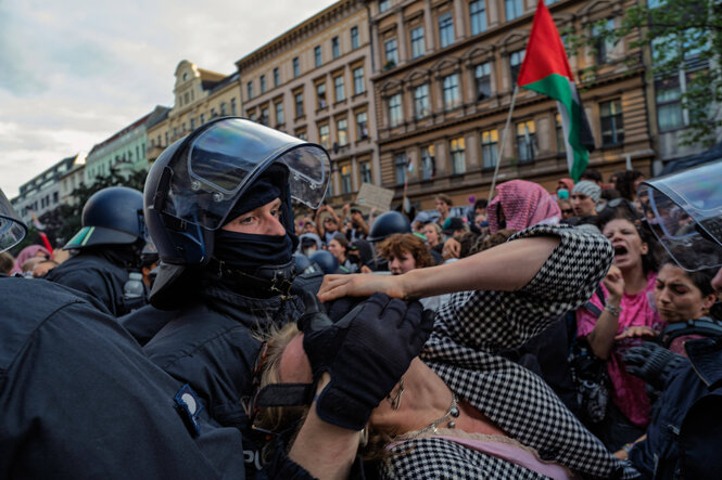 Eine Frau wird auf der Internationalist Queer Pride von Polizisten mit einem Schmerzgriff verhaftet