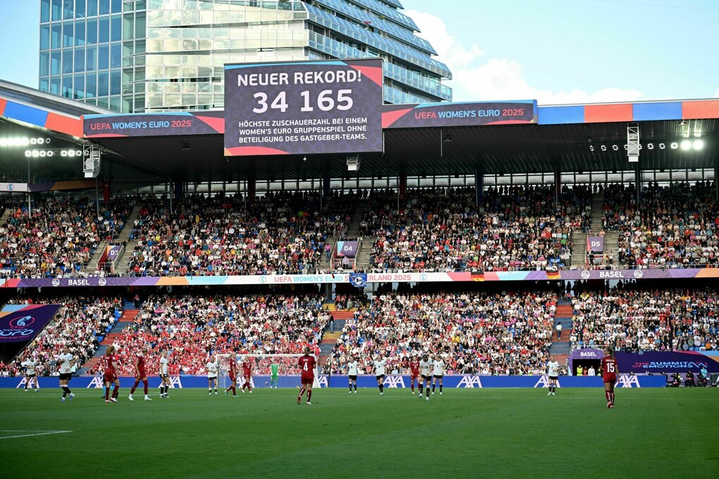 Stadiontribünde mit Anzeigetafel, die Zuschauerrekord vermeldet