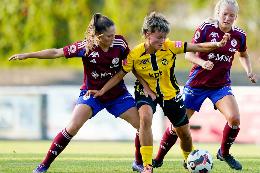 Noa Schär mit Ball am Fuß, wird von zwei Gegenspielerinnen bedrängt