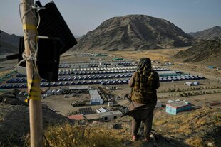 Ein Taliban-Kämpfer bewacht ein Lager von afghanischen Flüchtlingen, die Pakistan in den letzten Monaten verlassen mussten