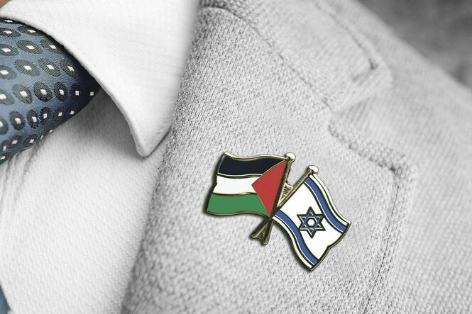 Eine Stecknadel am Revers mit den Flaggen Palästinas und Israels