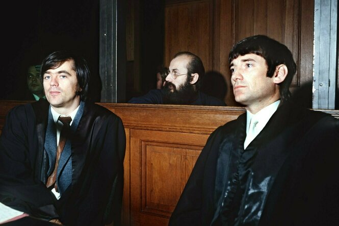 Die Rechtsanwälte Hans-Christian Ströbele (l) und Otto Schily unterhalten sich während eines Prozesses mit ihrem Mandanten Horst Mahler (M).