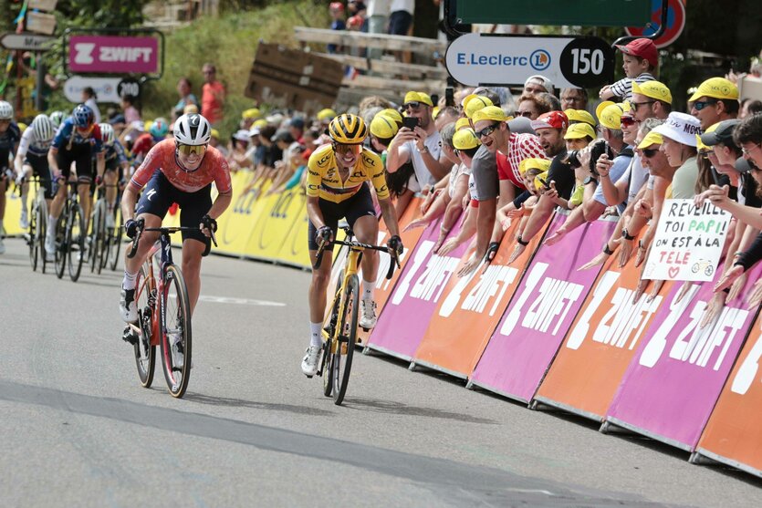 Zwei Frauen auf Rennrädern sprinten um die Wette, am Rand jubeln die Fans