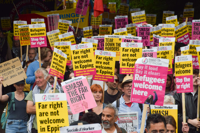 Demonstrierende halten Protestschilder hoch