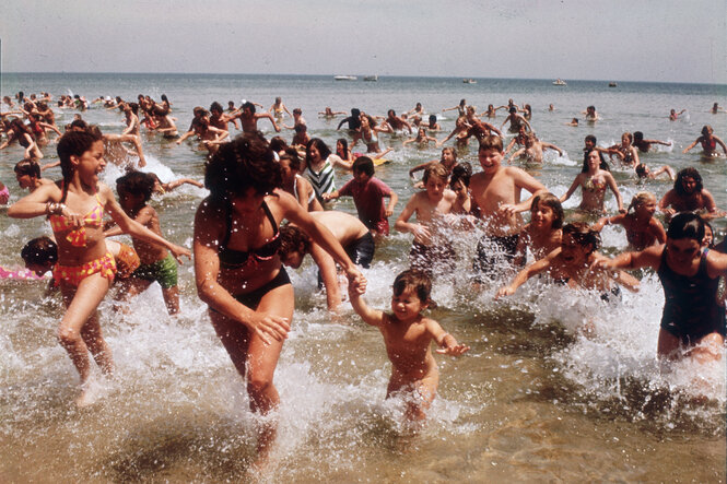 Menschen rennen am Strand aus dem Wasser