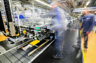 Mitarbeiter arbeiten im Karosseriebau an Neuwagen am Fließband