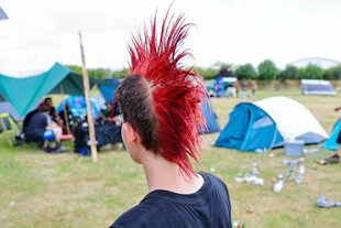 Ein Mensch mit roter Irokesenfrisur