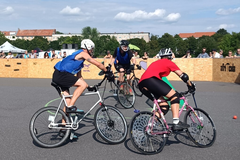 Drei Radfahrende beim Bikepolo