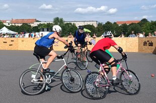 Drei Radfahrende beim Bikepolo