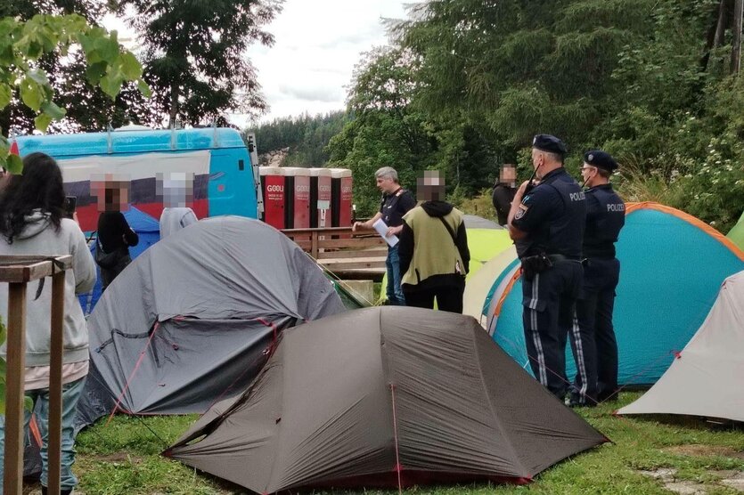 Polizisten umringen mehrere kleine Zelte