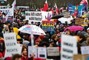 Menschen demonstrieren mit Schildern auf der Straße