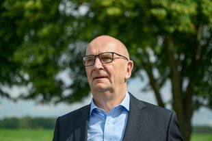 Dietmar Woidke (SPD), Ministerpräsident von Brandenburg, bei einem Besuch beim Demeter-Betrieb Ökodorf Brodowin. Er steht vor einem Baum