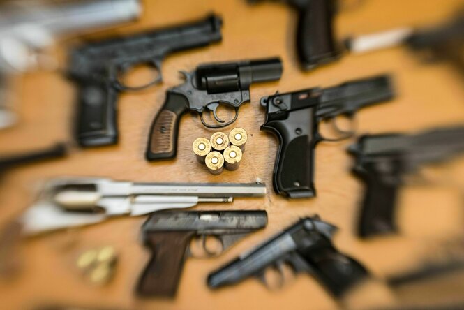Mehrere Schusswaffen auf einem Tisch.