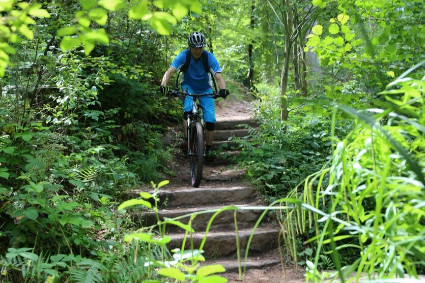 Mountainbikefahrer im Sprung auf einem holprigen Trail