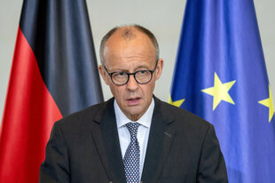 Mann vor Flaggen