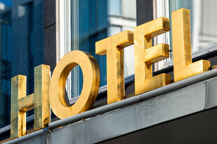 Schriftzug "Hotel" am Eingang eines Gebäudes