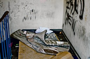 Im Hausflur der Ritterstraße ist alles vertaggt und Pappe und Decke liegen auf dem dreckigen Boden.