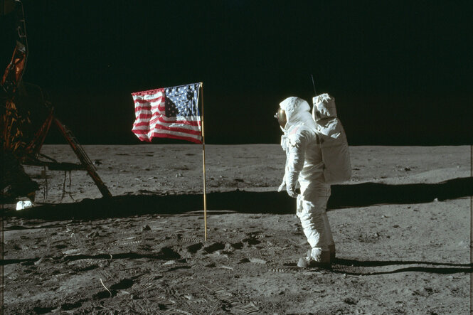 Astronaut auf dem Mond mit wehender amerikanischer Flagge