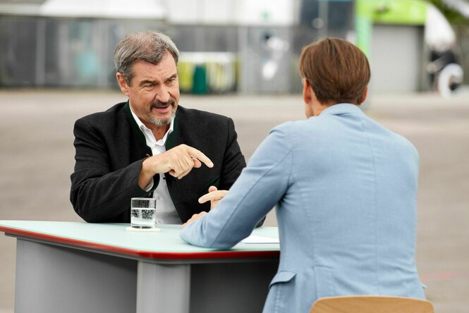 Zwei Männer sitzen an einem Tisch und unterhalten sich