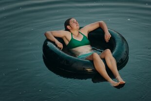 Katinka (Karolin Nothacker) treibt auf einem Gummireifen im Wasser
