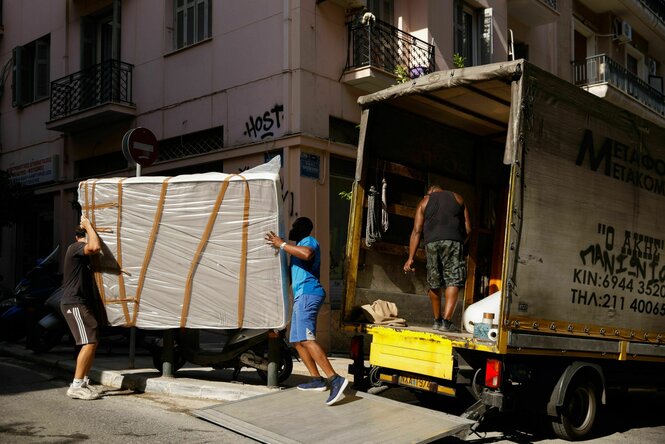 Arbeiter tragen eine Matratze während eines Umzugs