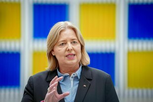 Eine Frau spricht mit Vertretern der Presse