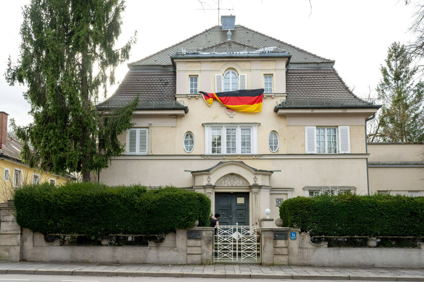 An der Fassade einer Villa hängt eine Deutschlandflagge