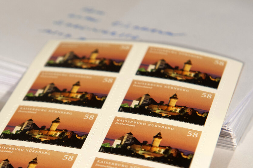 Ein Bogen mit Briefmarken der Deutschen Post liegt am 02.01.2013 in Berlin vor einem Briefstapel