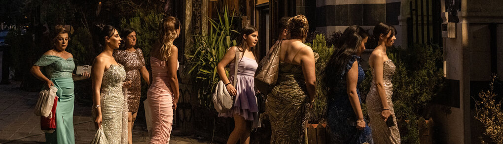 Festlich gekleidete Frauen abends auf dem Weg zu einer Hochzeitsfeier