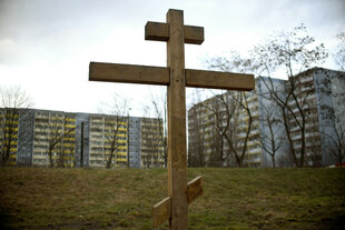 Ein orthodoxes Holzkreuz steht in Berlin-Marzahn vor Plattenbauten auf dem Gelände der Russisch Orthodoxen Kirche