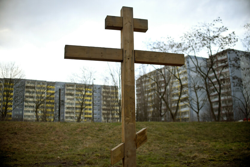 Ein orthodoxes Holzkreuz steht in Berlin-Marzahn vor Plattenbauten auf dem Gelände der Russisch Orthodoxen Kirche