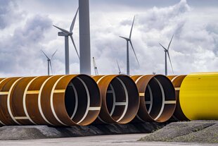Große Rohre für Windkraftanlagen liegen nebeneinander auf dem Boden
