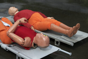 Zwei Crashtest Dummies auf Liegen