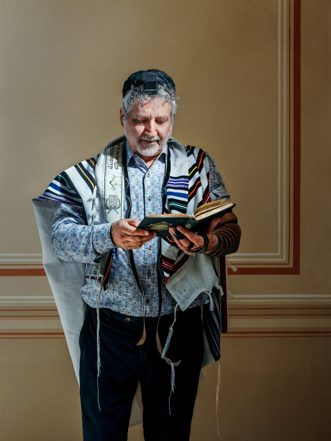Alex Jacobowitz in Gebetskleidung mit Buch in den Händen
