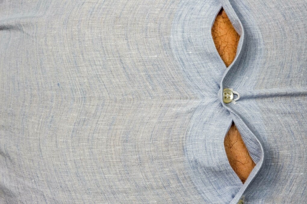 Ein Hemd spannt sich über den Bauch eines Mannes