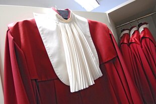 Eine rote Richterrobe hängt an einem Bügel