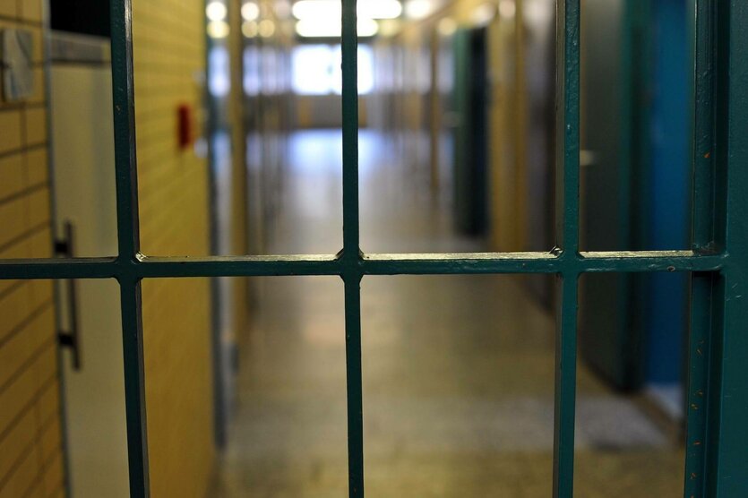 Blick durch eine Gittertür in einen Gang