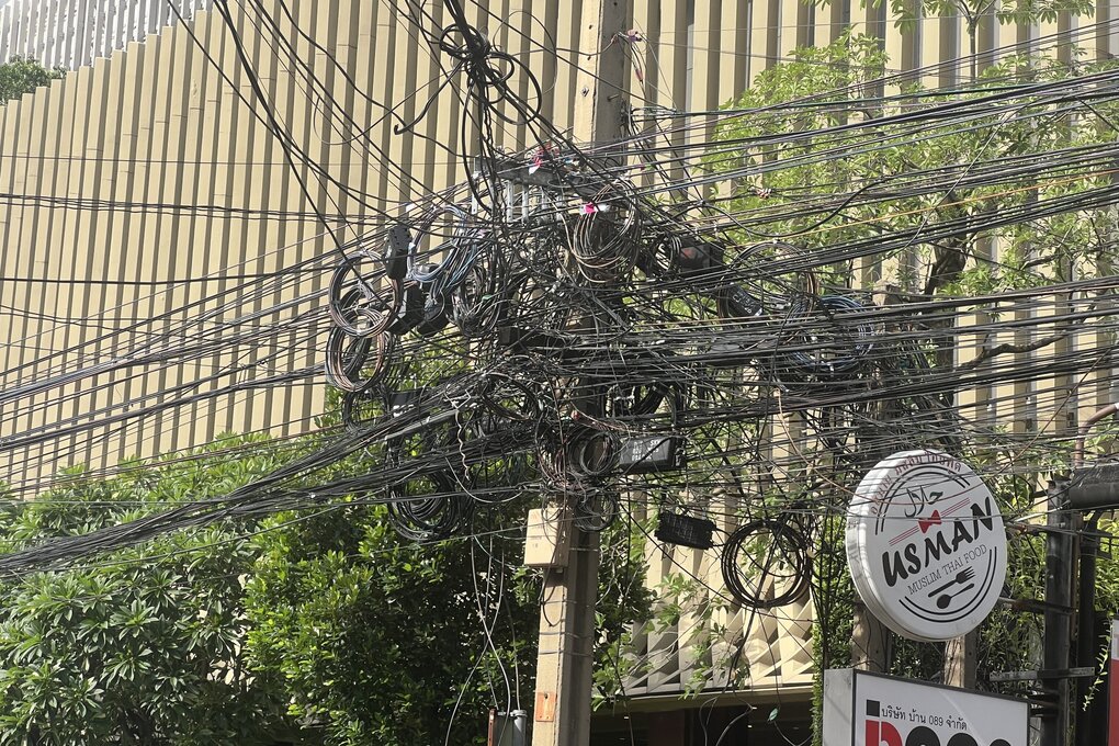 Ein Knäuel oberirdisch verlegter Stromkabel in Bangkoki