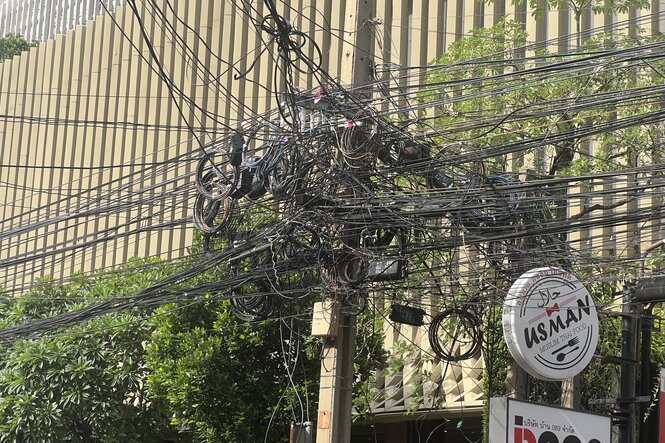 Ein Knäuel oberirdisch verlegter Stromkabel in Bangkoki