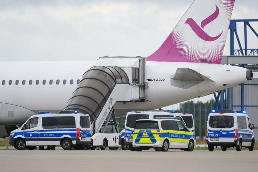Polizeifahrzeug fahren am 22. Juli auf dem Flughafen Leipzig/Halle an einem Airbus vor, der einen Abschiebeflug nach Bagdad durchführt
