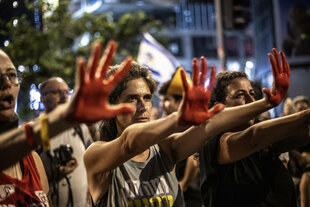 Menschen mit Transparenten und israelischen Flaggen protestieren für ein Ende des Krieges in Gaza und die Rückkehr israelischer Gefangener