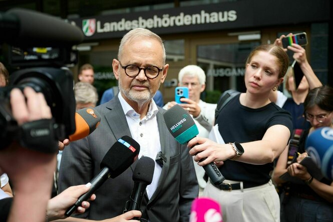 Ein Mann spricht zu Vertreter:innen der Presse